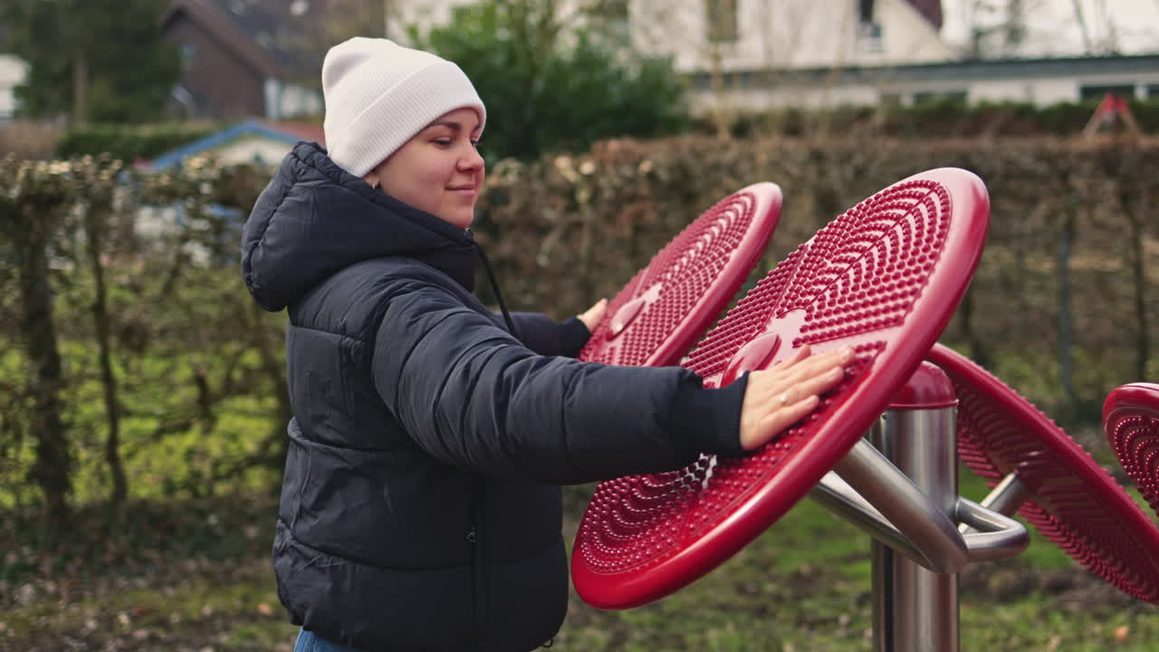 Una giovane donna fa esercizi su un simulatore speciale per ripristinare il sistema nervoso. Sport all'aperto per migliorare la salute