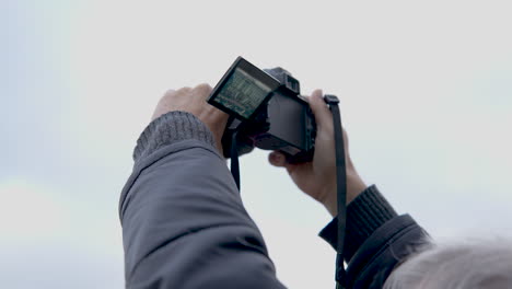 tourist taking pictures with camera at buckingham palace london, close up