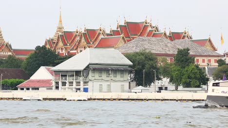 ferry travels past temple in bangkok, thailand