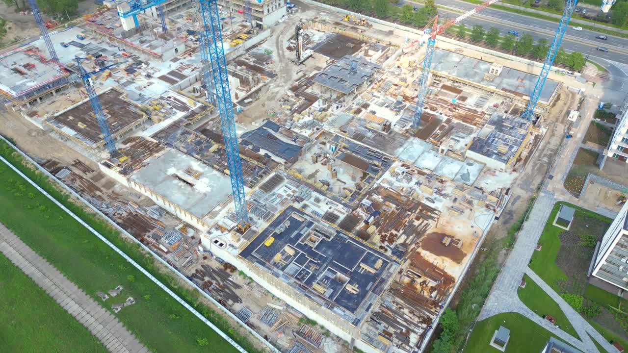 Aerial Bird Eye View Of a Construction Site Building Cranes Looking Down Industrial Machinery Area around Residential Urban Apartments