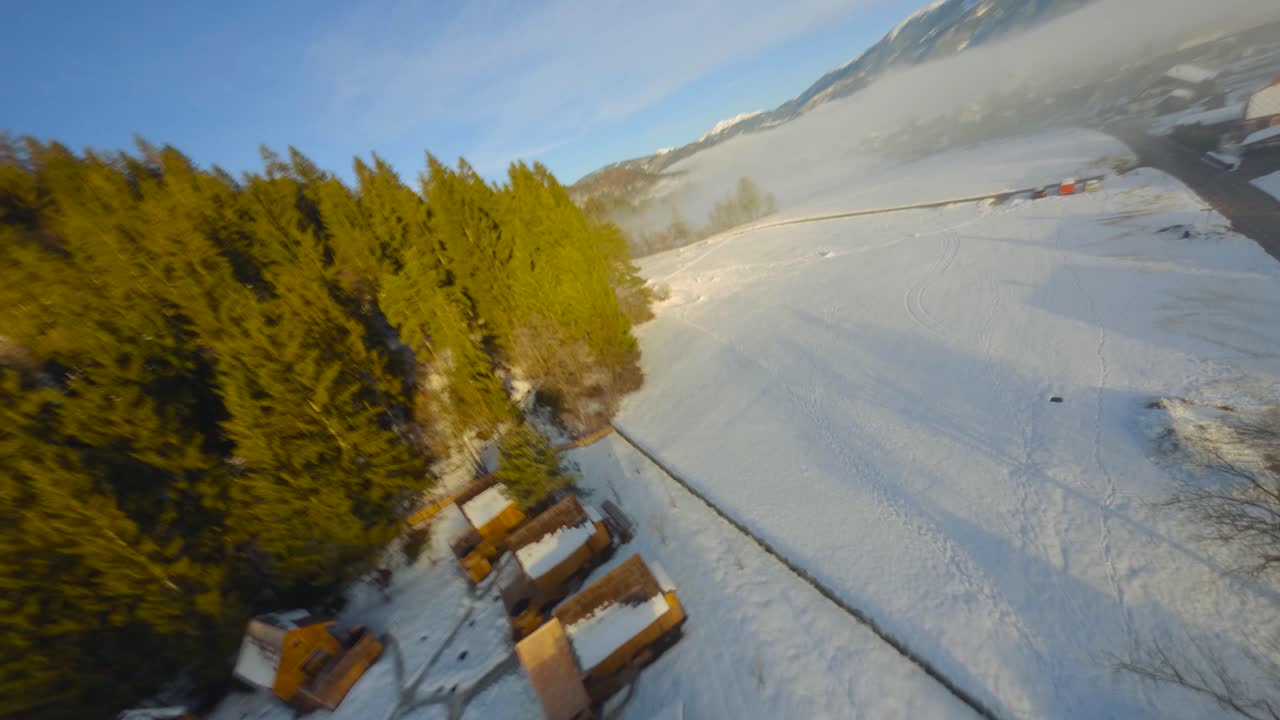 Ripresa da drone FPV del paesaggio sloveno avvolto nella nebbia con montagne circostanti al mattino d'inverno, catturato in 4K, con il drone che vola velocemente, vicino agli oggetti e con molto movimento.