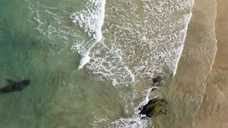 Ocean-Waves-Splashing-On-Sandy-Shore-At-Lusty-Glaze-Beach-In-Newquay,-United-Kingdom