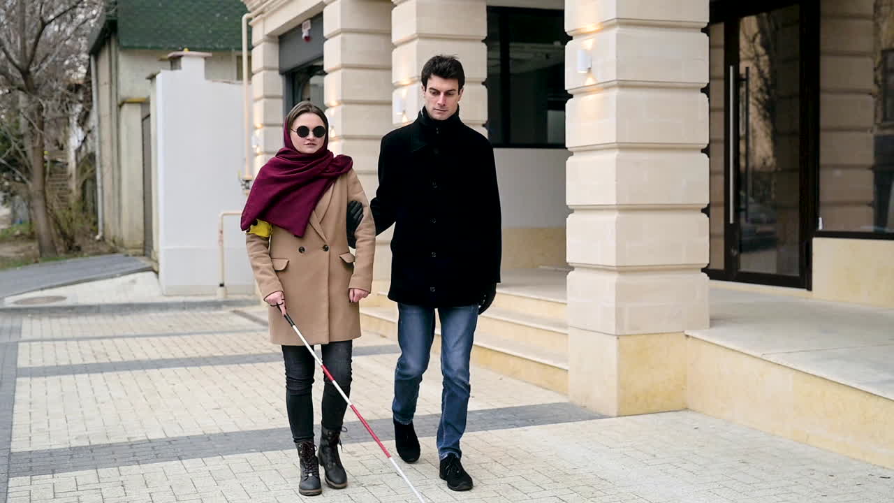Front View Of A Man And A Blind Woman Walking In The Street 1