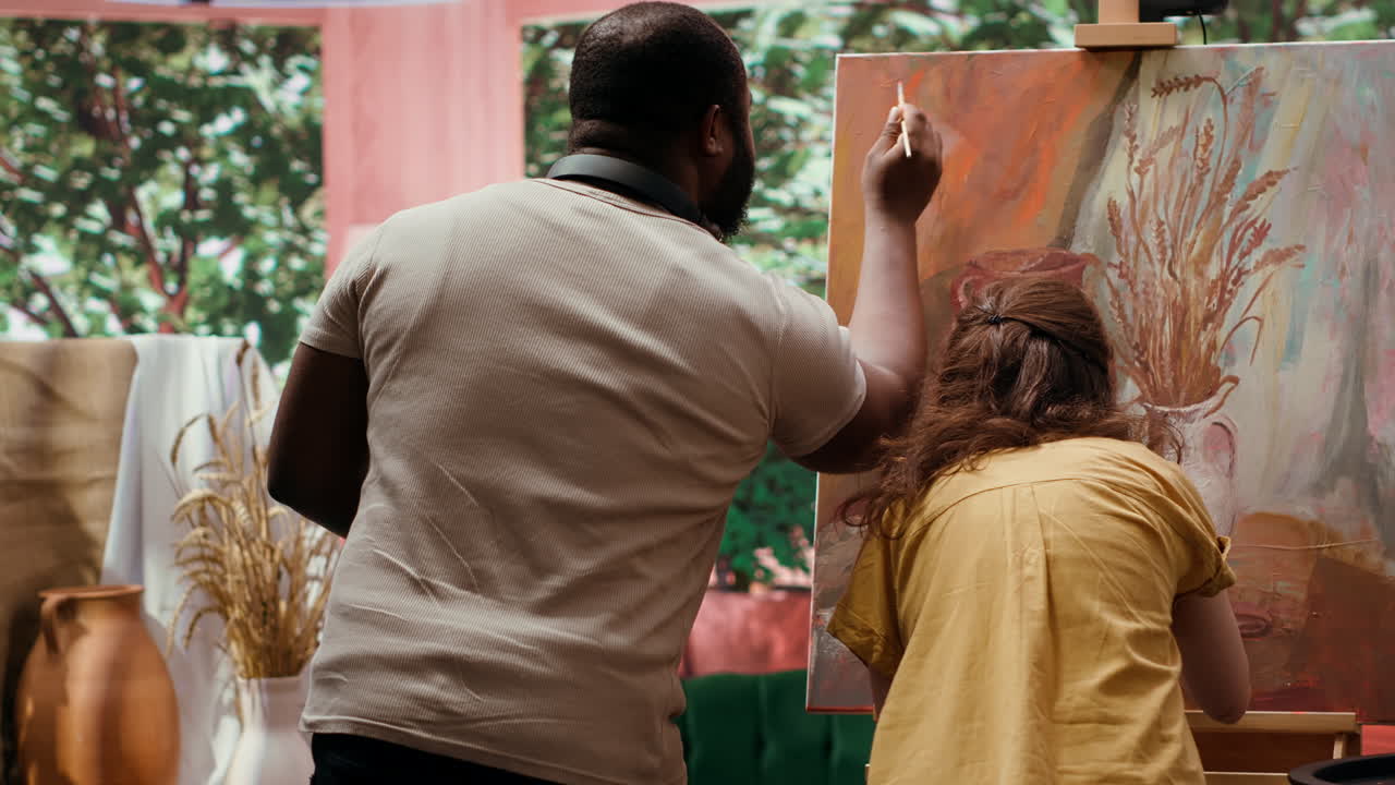 Two people painting together in a studio