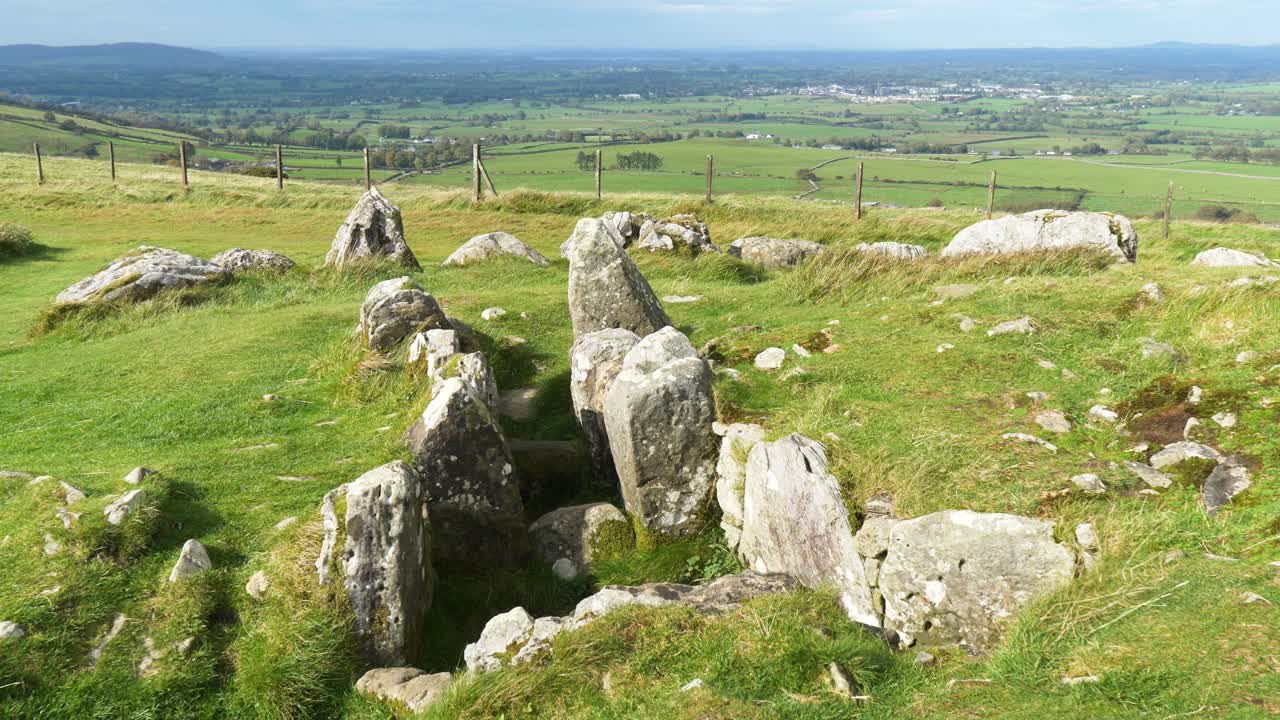 Lăng mộ Loughcrew cổ kính giữa khung cảnh đồng quê xanh tươi của Ireland dưới bầu trời xanh