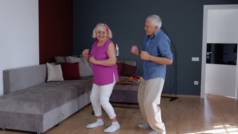 Feliz-Pareja-De-Ancianos-Bailando-Divirtiéndose-Celebrando-El-Aniversario-De-Jubilación-En-El-Salón-De-Casa