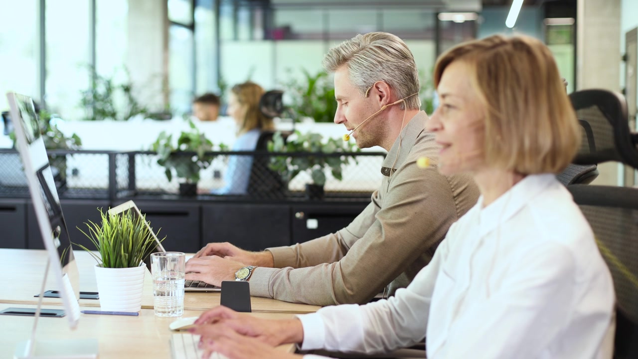 Callcenteragenter arbejder ved computere på et moderne kontor