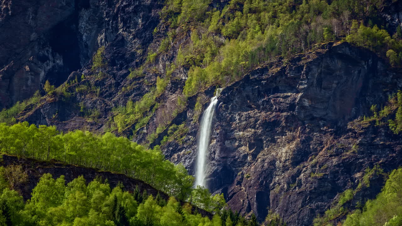 lapso de tiempo de una cascada de agua en un acantilado en la ladera de una montaña, cascada brekkefossen