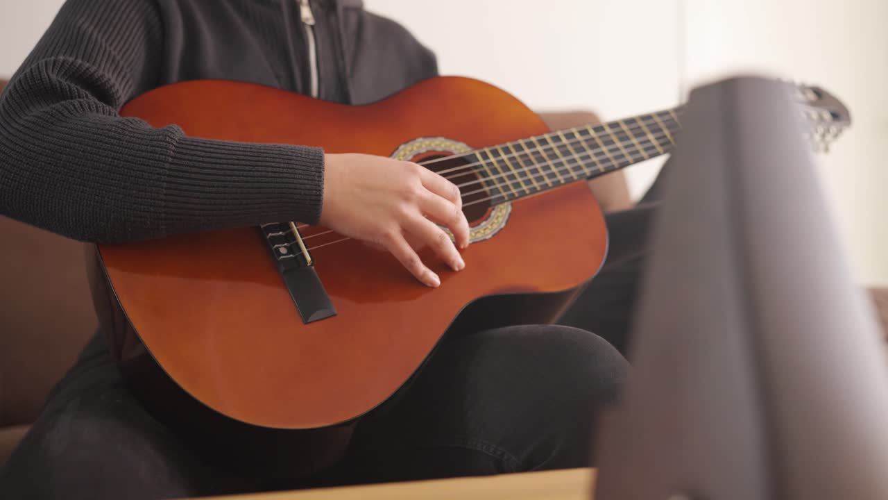 Hands skillfully playing acoustic guitar close-up indoor