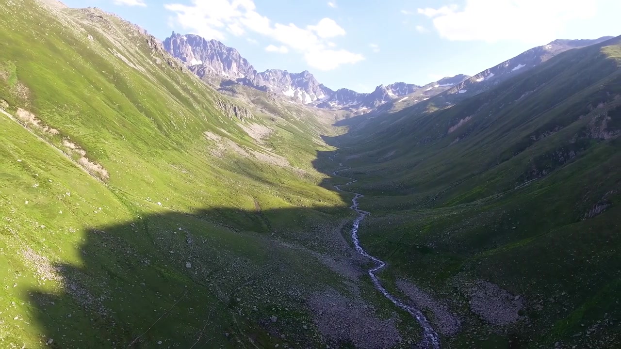 Aerial View of a Lush Green Mountain Valley with a Winding Stream