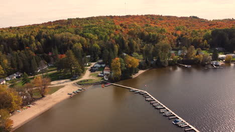 Boats-Docked-At-The-Resort-Near-Forest-Mountains-With-Autumnal-Foliage-In-Algonquin-Provincial-Park,-Ontario,-Canada