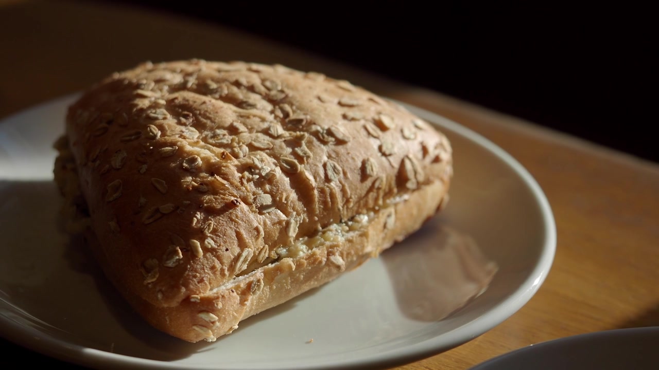Primo piano di un sandwich fresco all'avena su un piatto bianco.