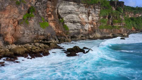 Foamy-Ocean-Waves-And-Cliffs-In-Uluwatu,-Bali,-Indonesia---drone-shot