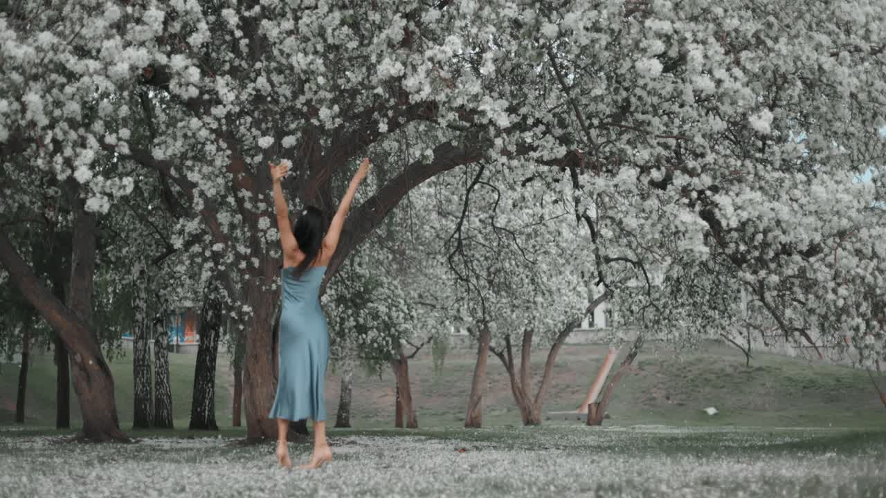 Woman Dancing in a Blooming Spring Park