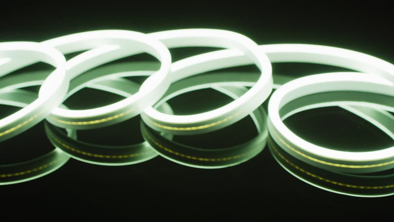 검은 바탕에 나선형 모양의 색 네온 불빛의 애니메이션