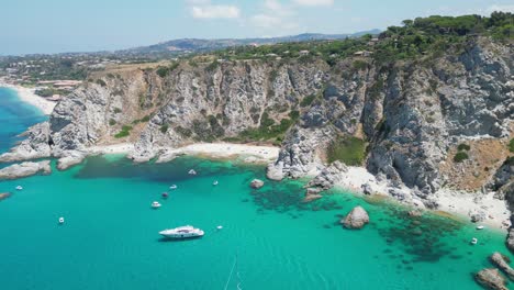 capo vaticano beaches, boats and blue mediterranean sea in calabria, south italy - aerial 4k