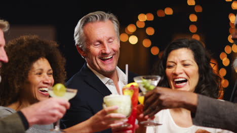 group of middle aged friends celebrating in bar together