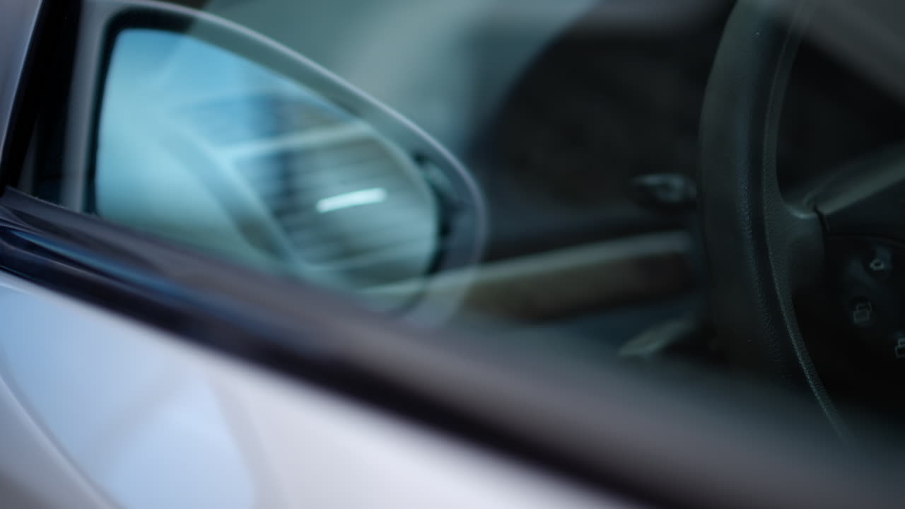 Close up of the mirror and the front window of a silver car