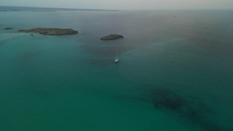 Lonely-sailboat-anchors-for-sunset-at-offshore-island