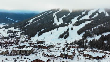 Fog-cloud-layer-winter-snowy-early-morning-sunrise-aerial-drone-Copper-Mountain-Colorado-ski-resort-Eagle-Flyer-lift-center-village-half-pipe-Ikon-Epic-pass-snowboarding-forward-circle-pan-parallax