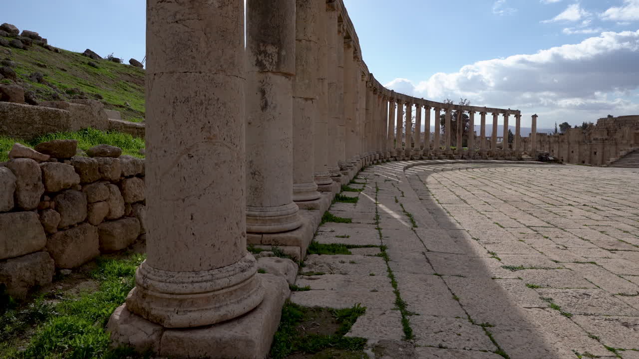 una línea de pilares corintios de piedra dentro de la plaza del foro en ruinas romanas en la ciudad jordana de jerash