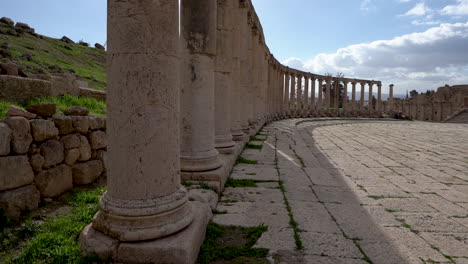 a line of stone corinthian pillars inside of forum plaza in roman ruins in the jordanian city of jerash