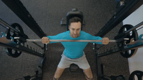 top view of a person doing seated barbell shoulder press for shoulder muscles in smith machine