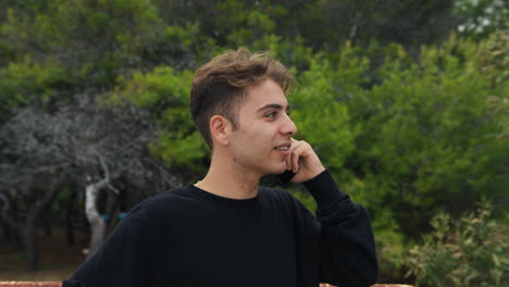 boy talks on the phone excitedly about receiving good news outdoors