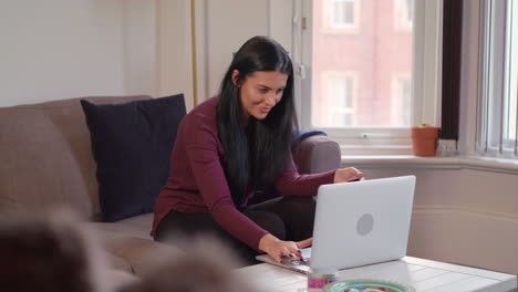 Slow-Motion-Shot-Of-Young-Attractive-Woman-Using-Laptop-To-Shop-Online-And-Being-Over-Come-With-Joy-On-Completion-Of-The-Purchase