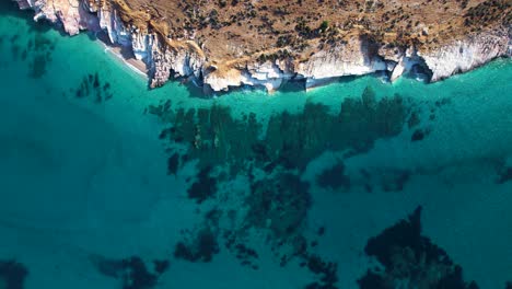 Emerald-Sea,-Fabulous-Aerial-View-of-the-Clean,-Crystal-Clear-Mediterranean-Sea-against-a-Rocky-Shore,-a-Coastal-Spectacle-in-Albania