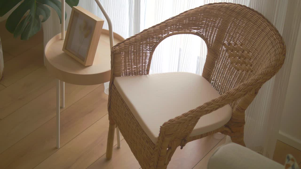 A wicker chair next to a side table in a room