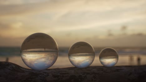 three crystal balls in golden sunset on a timber.