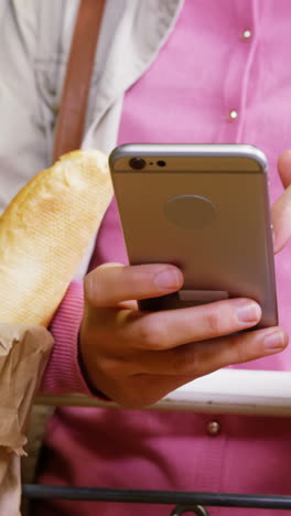 mujer usando el teléfono móvil mientras hace compras