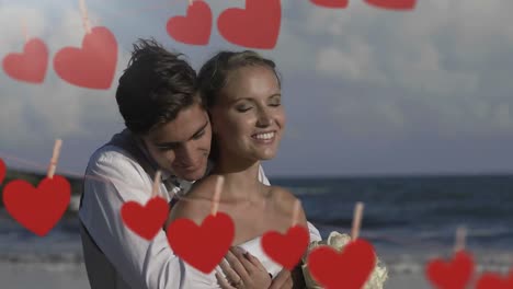 pareja abrazándose y besándose en la playa para el día de san valentín