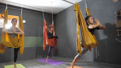 women practicing aerial yoga