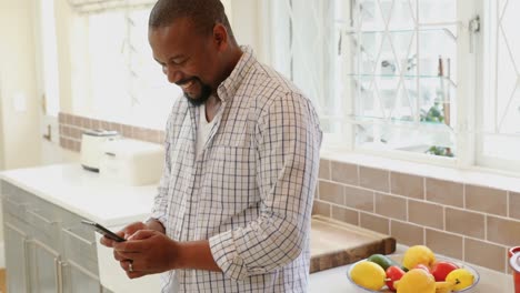 Man-using-mobile-phone-in-kitchen-4k