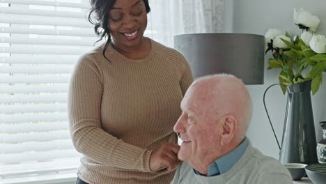 a caregiver assisting a senior man at home