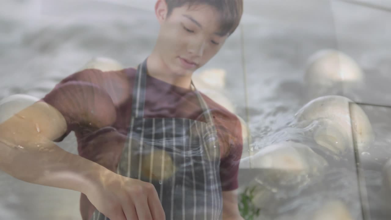 Teen boy sprinkling cheese on dough and mixing sauce causing splash overlay animating cooking