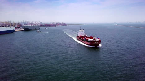 aerial view of logistics concept cargo ship sailing out to the open sea leaving laem chabang dockyard in chonburi province, thailand