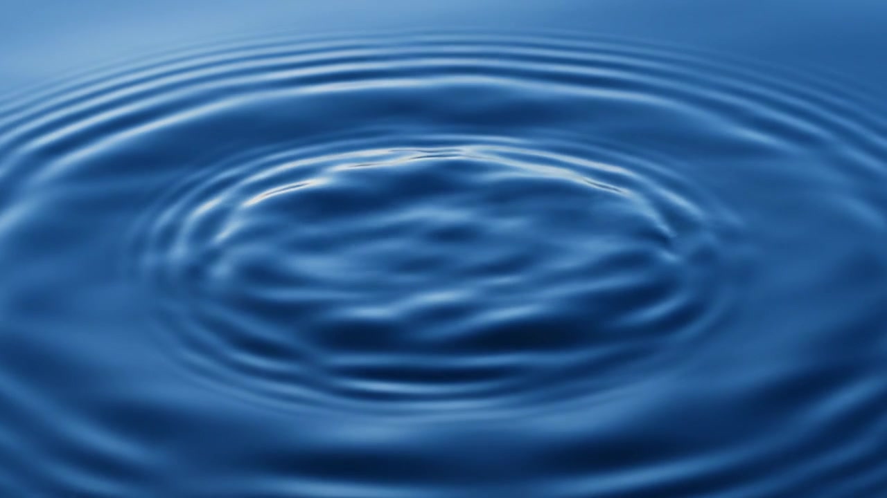 Impatto di una goccia d'acqua che crea increspature concentriche su una superficie blu calma