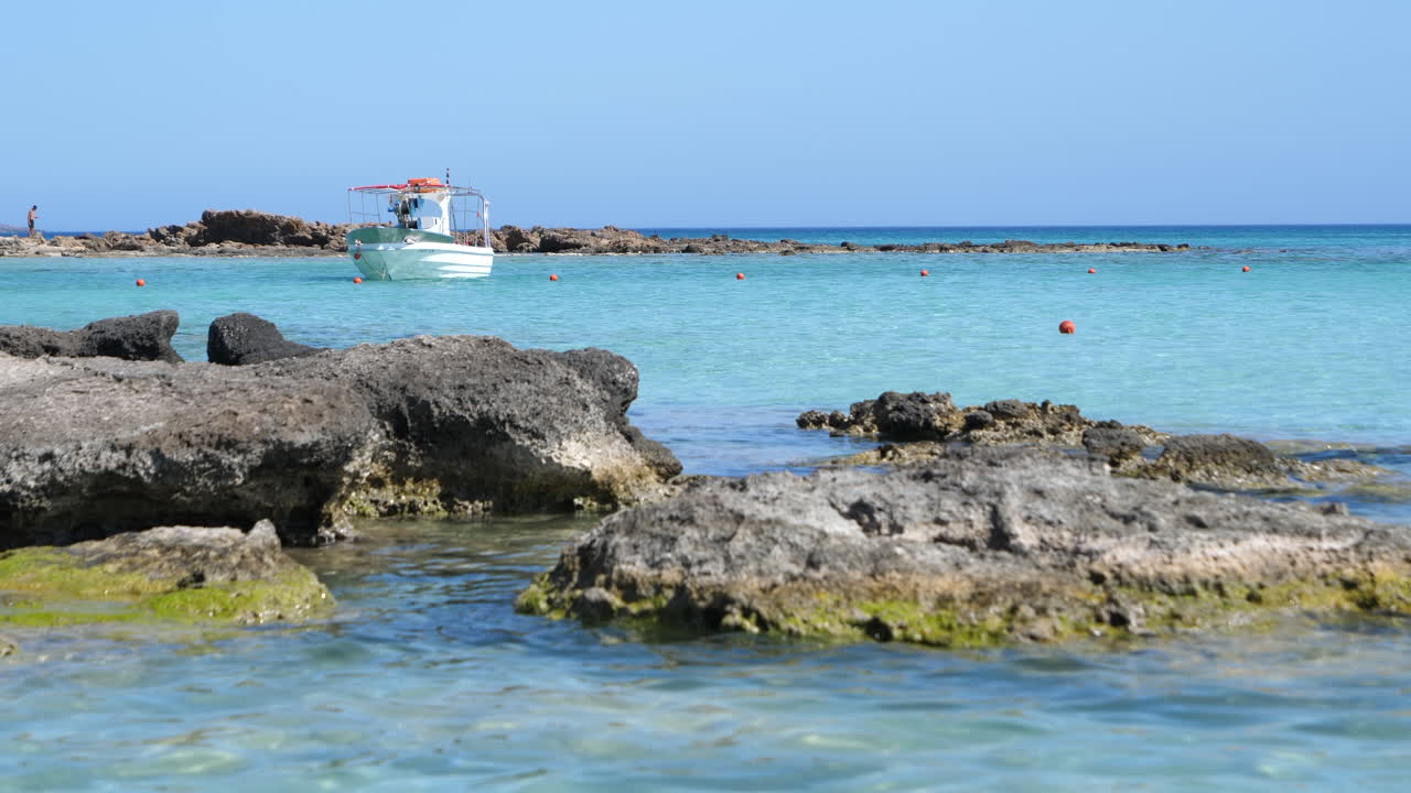 barco flotando en el mar en la playa de elafonissi durante el verano en la isla de creta, grecia