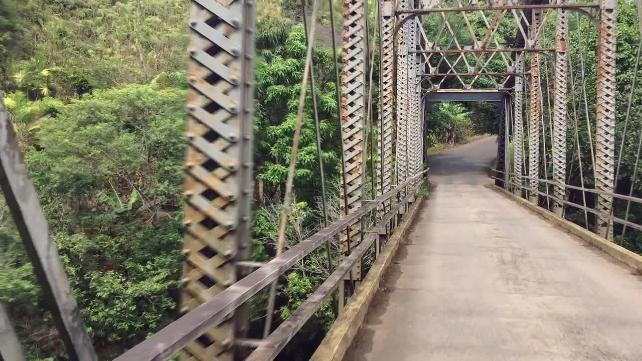 열대우림의 오래된 녹슨 금속 다리를 통해 운전