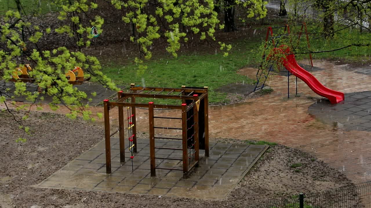 nieve que cae en el patio de recreo en el parque de la ciudad en primavera en ventisca en el día