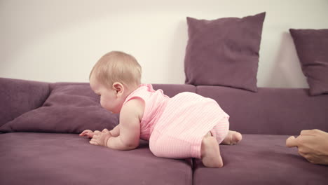 Baby-crawling-away-mother.-Cheerful-kid-walking-on-sofa