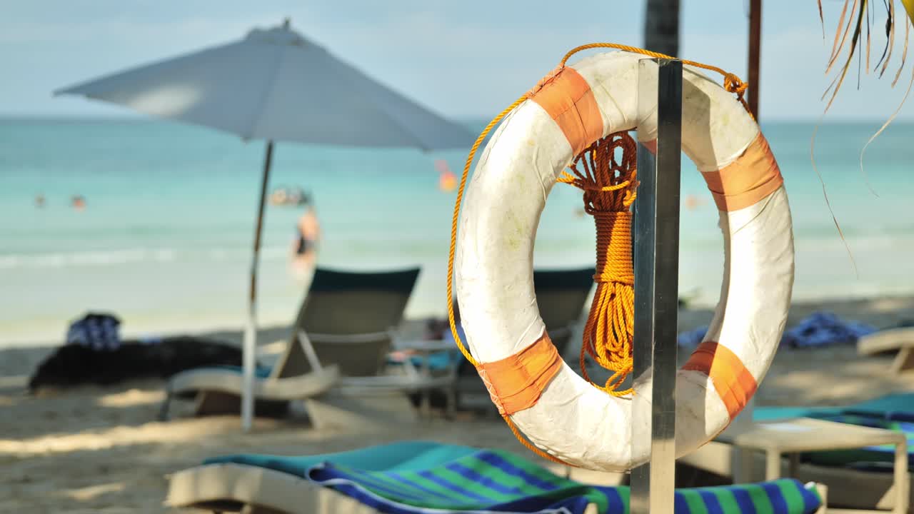 Anello di galleggiamento di sicurezza sulla spiaggia sabbiosa con ombrelloni e un'atmosfera marina rilassante