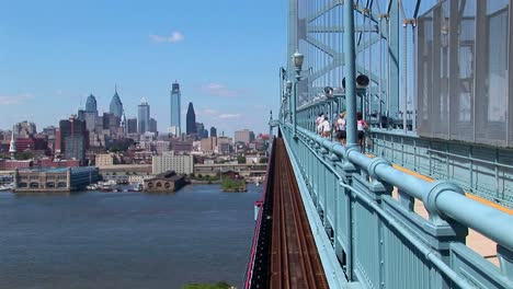 eine gruppe von joggern läuft über die ben franklin bridge, die nach philadelphia, pennsylvania führt