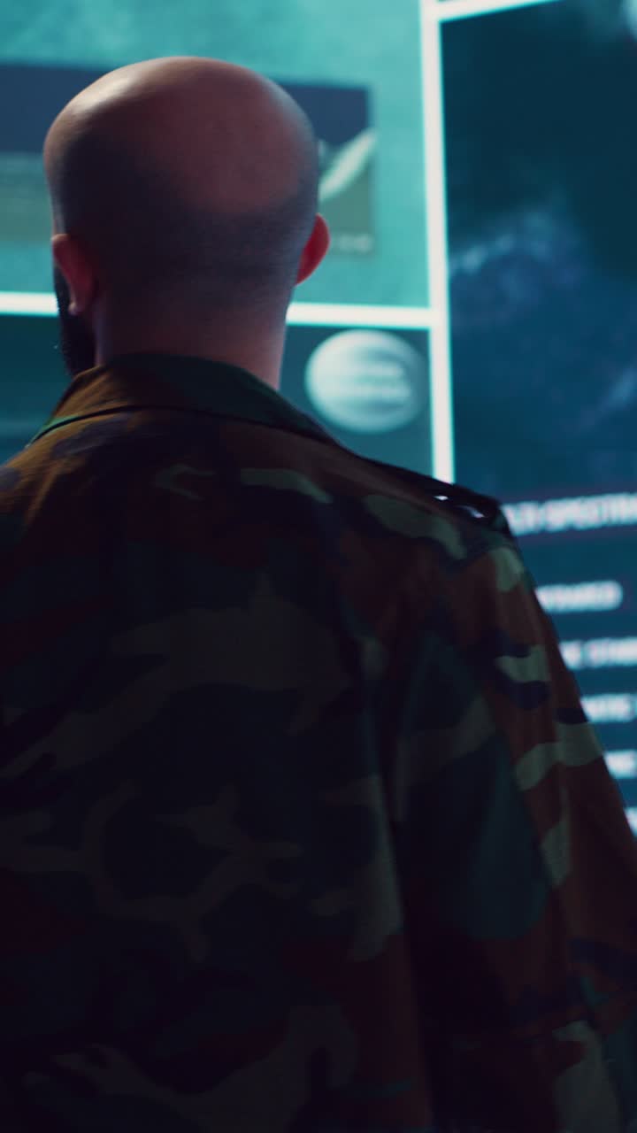 Military Man in Camouflage Jacket Analyzing Data on Large Screens