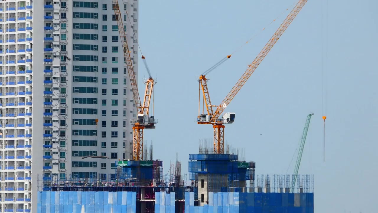 Video tua nhanh thời gian (timelapse) cần cẩu tháp hoạt động tại công trường xây dựng đô thị, ghi lại tiến độ xây dựng liên tục và sự phát triển thành phố hiện đại