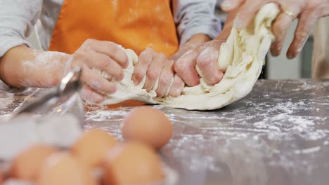 Happy-grandmother-and-child-kneading-dough-on-kitchen-table-4K-4k