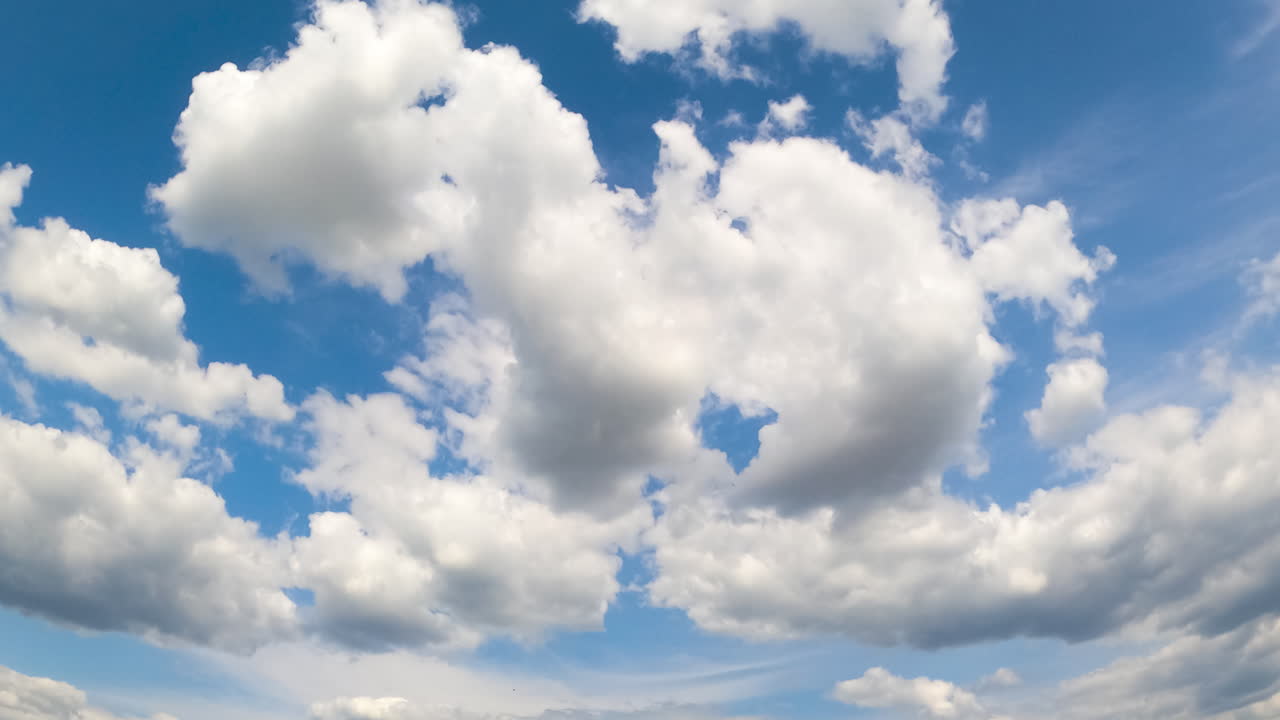 White cloudscape formation in the atmosphere. Summer sky with changing soft clouds. Low angle view timelapse.